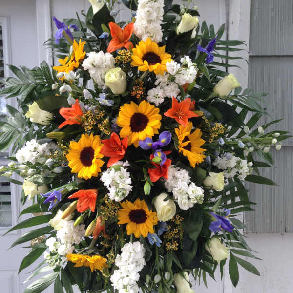 Large standing spray with sunflowers, lilies, and white roses