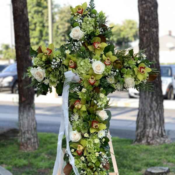 Large floral cross arrangement with white roses and green orchids