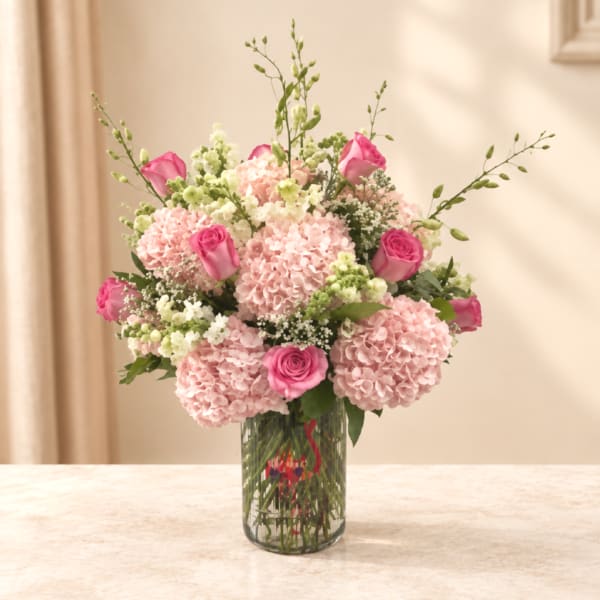 Pink hydrangea and rose bouquet in a clear glass vase