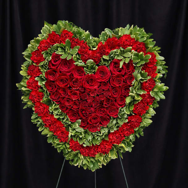 Heart-shaped red rose and carnation standing spray on an easel