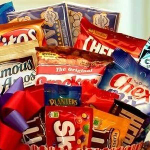 Gift basket filled with assorted snack and candy bags topped with a red and purple bow