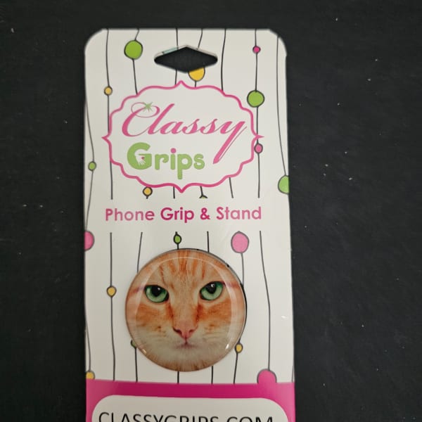 Packaged phone grip and stand with a cat face design