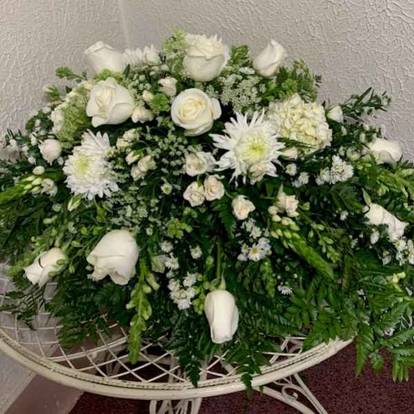White roses and chrysanthemums arranged in a low, lush spray