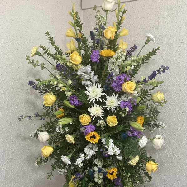 Tall standing floral spray with yellow, white, and purple flowers