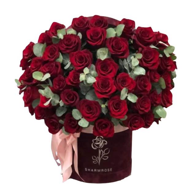 Bouquet of red roses in a burgundy hatbox with a pink ribbon