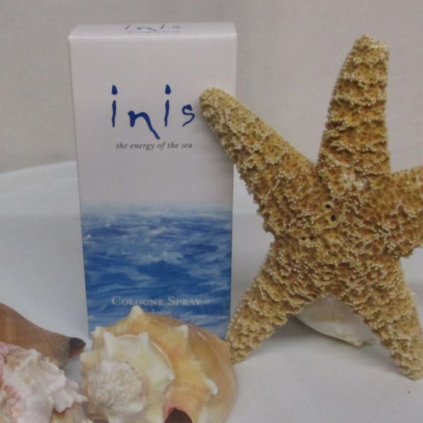 Seashells and a starfish arranged beside a cologne spray box
