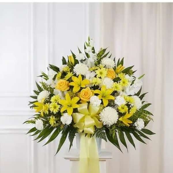 Yellow and white floral standing spray with a ribbon bow