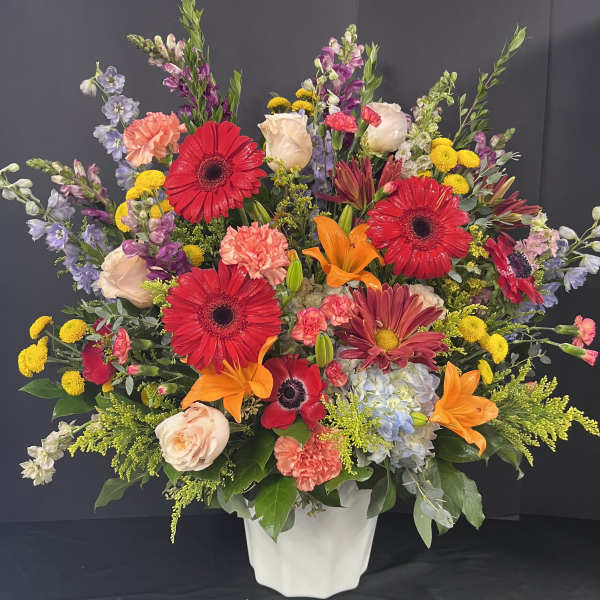 Colorful mixed flower arrangement in a white vase
