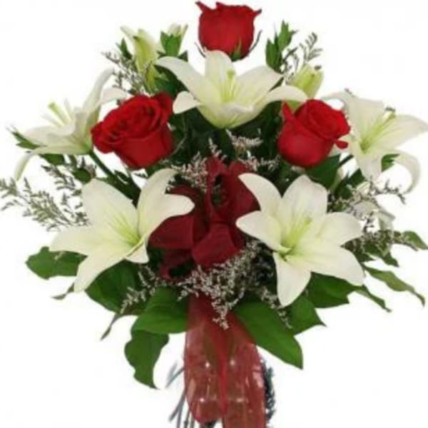Bouquet of red roses and white lilies in a clear vase