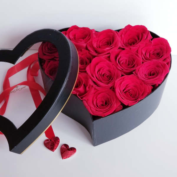Heart-shaped box of hot pink roses with a ribbon and heart decorations