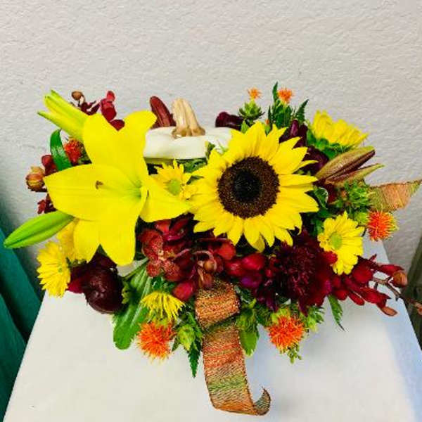 Bouquet with yellow lilies and sunflowers in a ribbon wrap