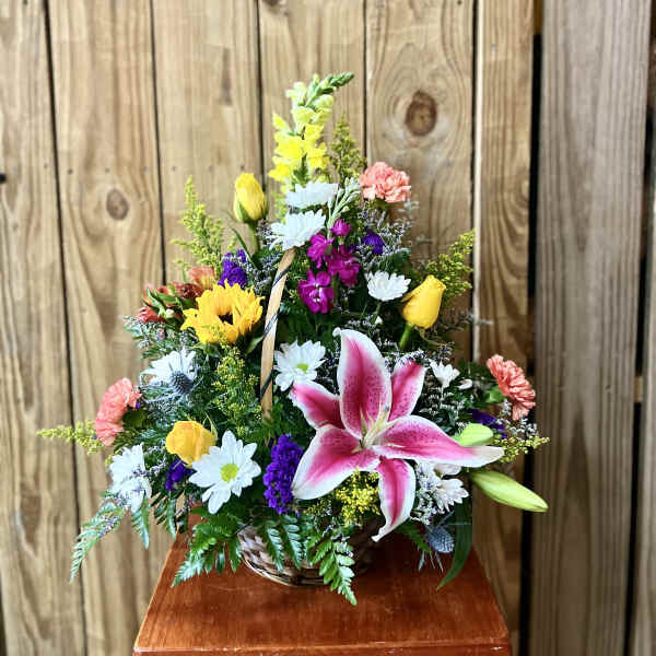 Mixed flower basket with pink lily, yellow roses, and white daisies