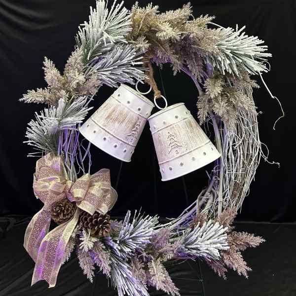 Decorative wreath with frosted branches, ribbon, pinecones, and hanging bells