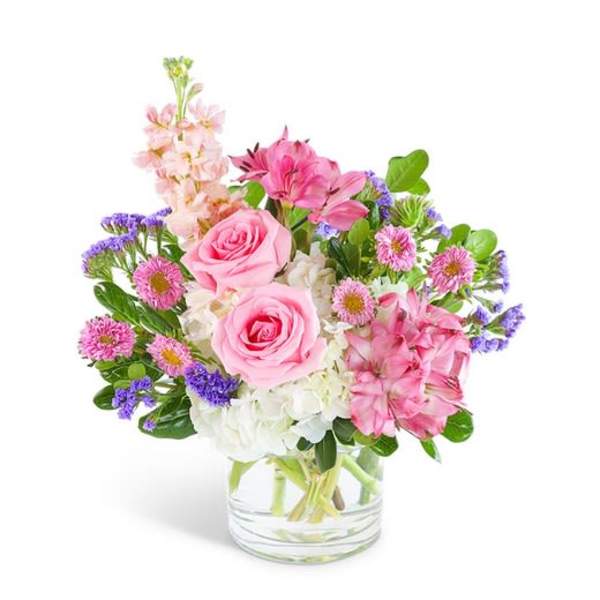 Pink roses and mixed flowers in a clear glass vase