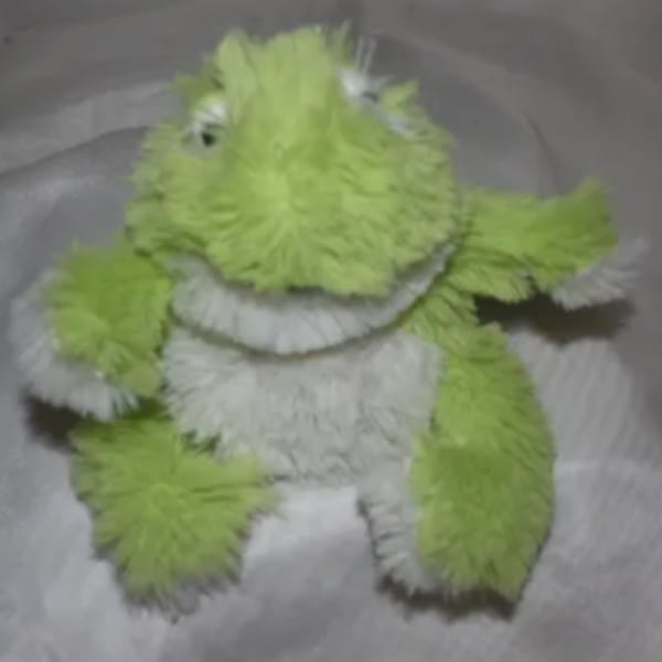 Green and white plush frog toy with fuzzy texture
