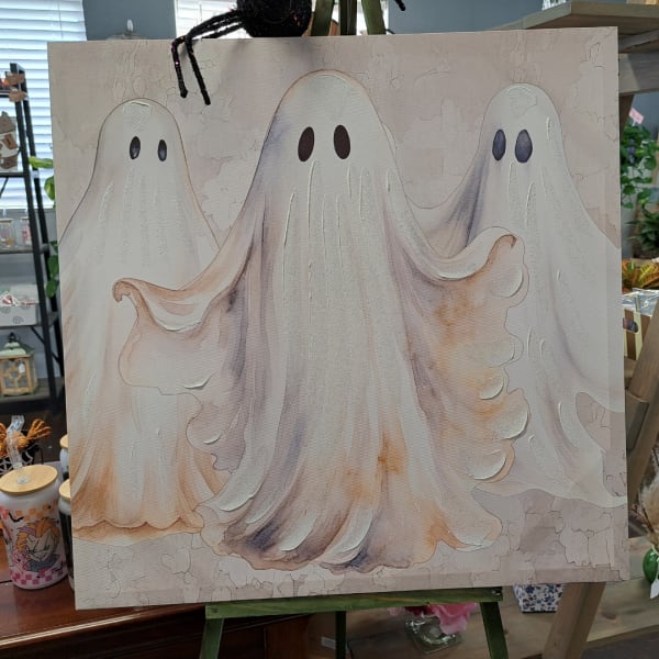 Canvas with three cartoon ghosts on an easel