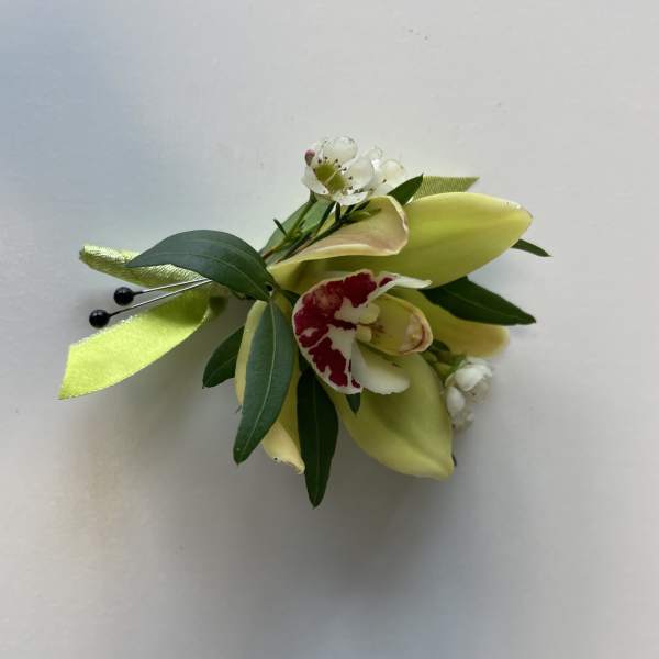 Small floral corsage with pale yellow calla lilies and white blossoms
