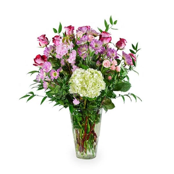 Mixed pink and white flowers arranged in a clear glass vase