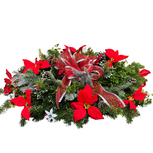 Holiday centerpiece with red poinsettias, pinecones, and a red ribbon bow