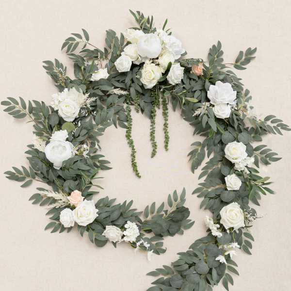 Large open wreath of cascading greenery with white roses and peonies and a touch of peach blooms