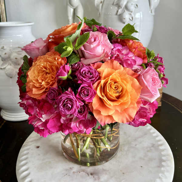 Mixed pink and orange roses in a clear glass vase