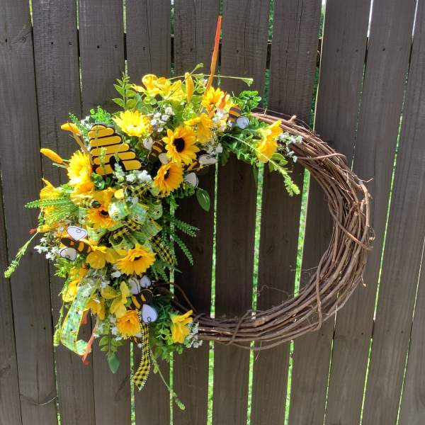 Yellow floral wreath on a grapevine ring with bee decorations