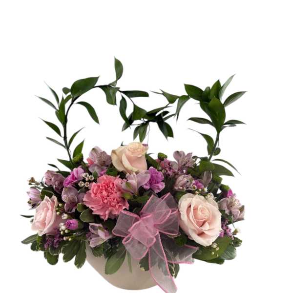 Pink and cream floral arrangement in a round box with a pink bow