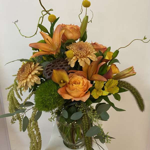 Orange and yellow floral arrangement in a clear glass vase