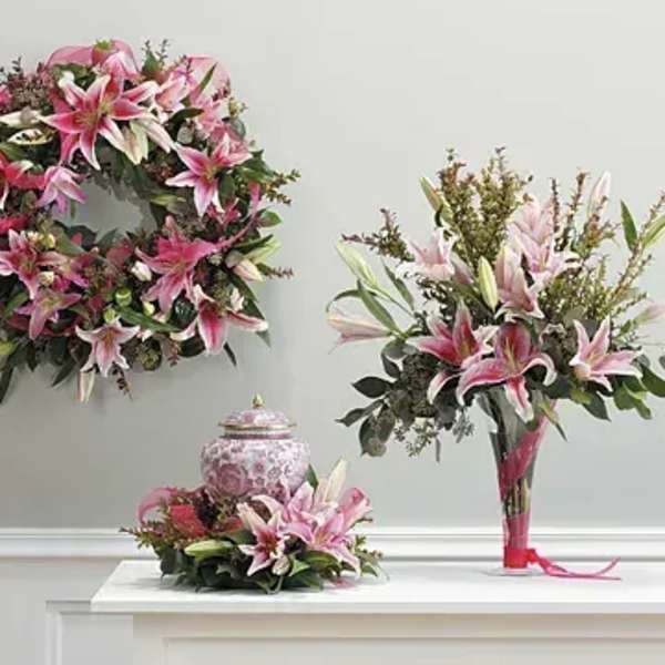 Pink lily floral wreath, bouquet, and centerpiece on a white table