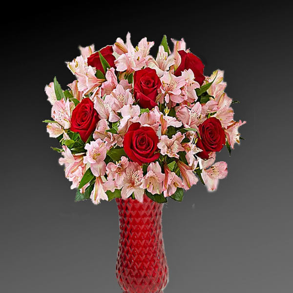 Red roses and pink lilies in a red glass vase