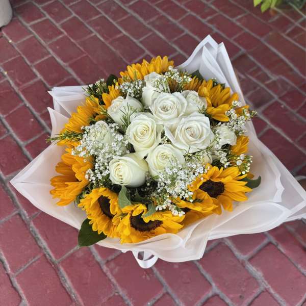 Bouquet of white roses and yellow sunflowers wrapped in white paper