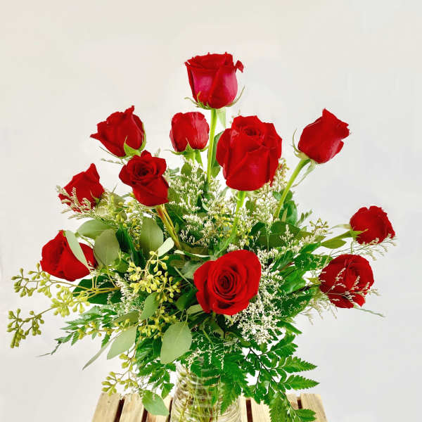 Red roses arranged in a clear glass vase