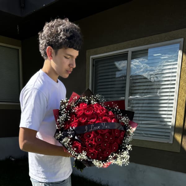 Large bouquet of red roses with baby's breath and a ribbon