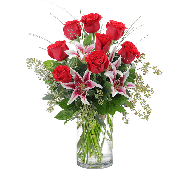 Red roses and pink lilies in a clear glass vase