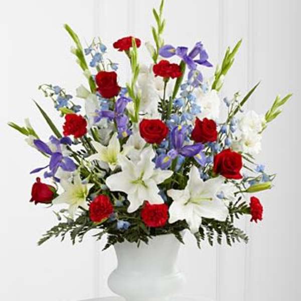 Red roses, white lilies, and purple flowers in a white vase