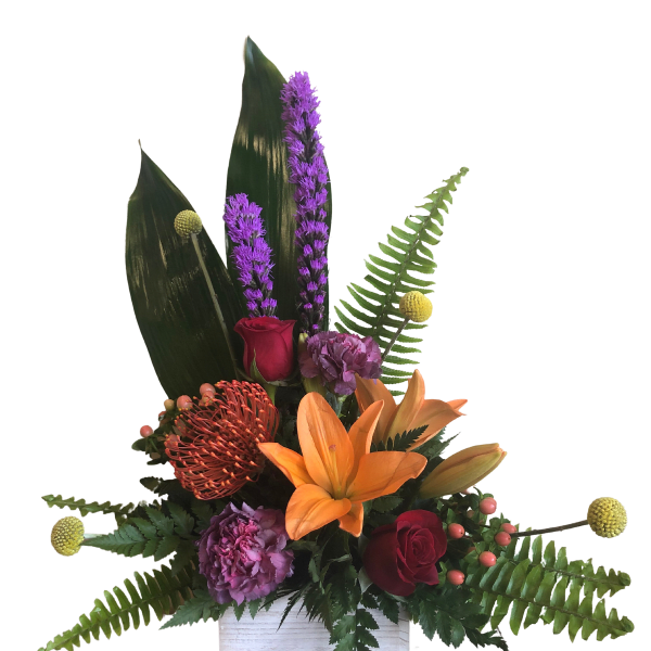 Tropical floral arrangement with orange lily, red roses, and purple blooms in a white box