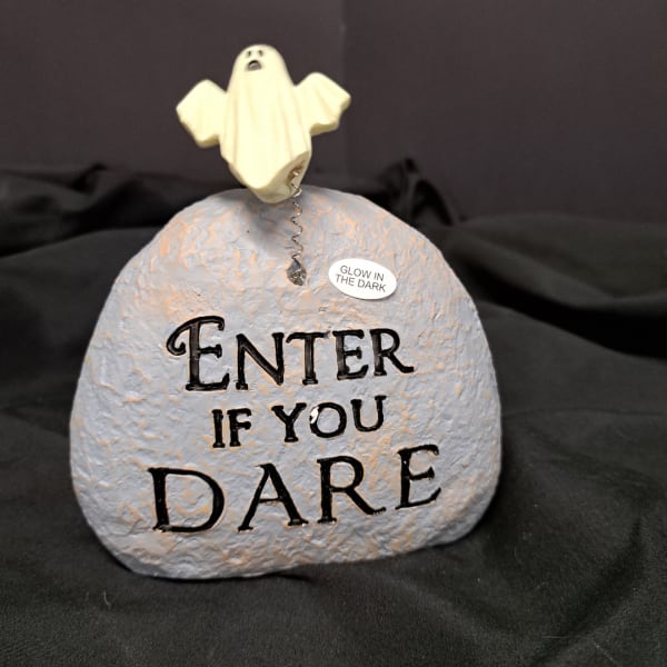 Ghost figurine on a painted stone with "Enter if you dare" text