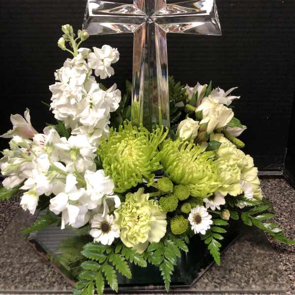 White and green floral arrangement with a glass cross centerpiece
