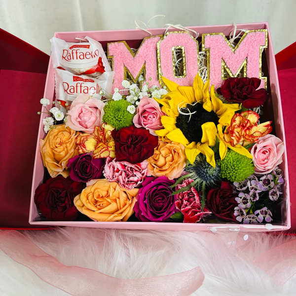 Gift box with pink MOM letters, roses, sunflowers, and chocolates