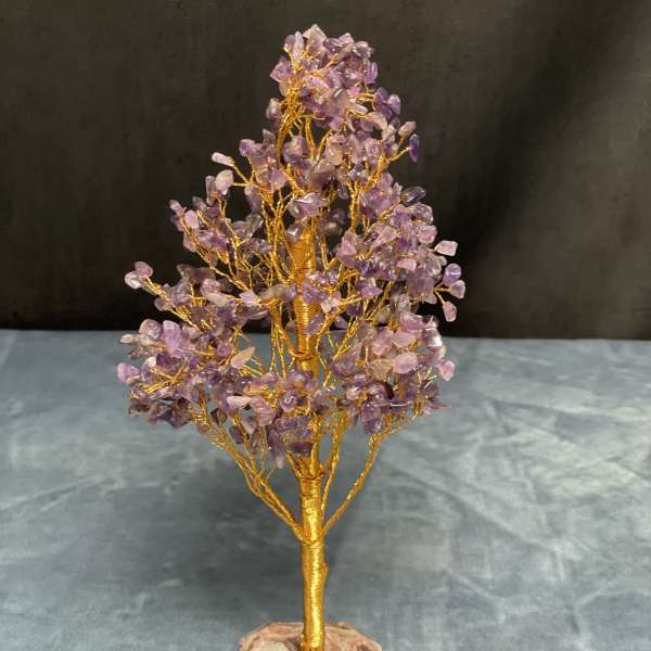 Gold wire gemstone tree sculpture with purple crystal chips on a stone base