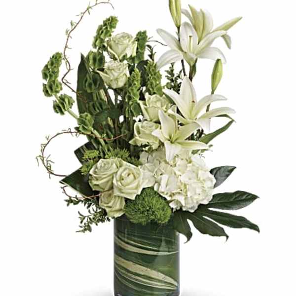 White lilies and roses arranged in a green glass vase