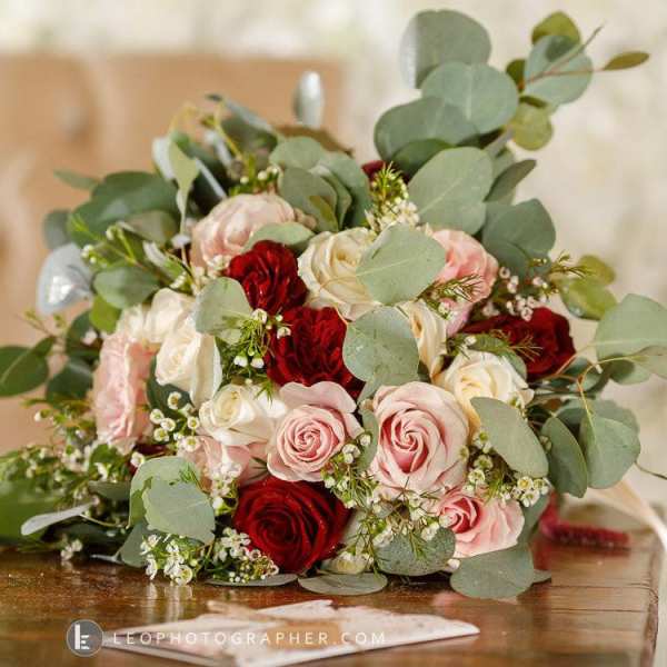 Bouquet of red, pink, and white roses with eucalyptus