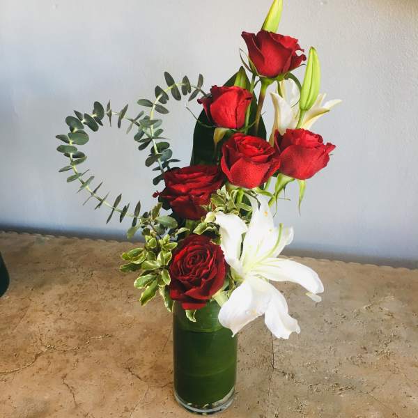 Red roses and white lilies in a tall green vase