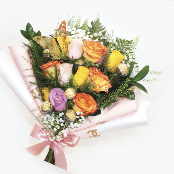 Bouquet of multicolored roses with a pink ribbon and gold butterfly decoration