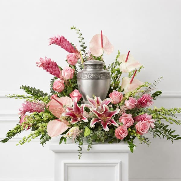 Pink floral arrangement with lilies, roses, and an urn centerpiece