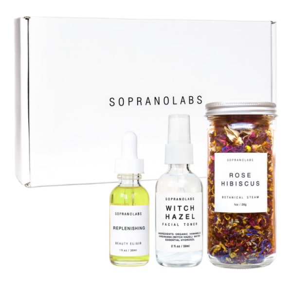 Skincare gift set with two dropper bottles and a jar of dried botanicals in a white box