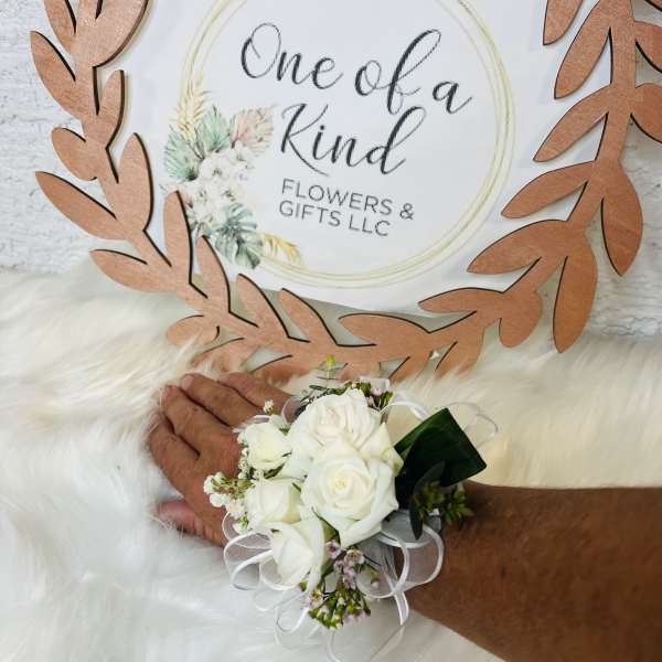 White rose wrist corsage with ribbon on a person's wrist