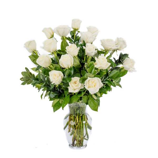 Tall arrangement of white roses in a clear glass vase