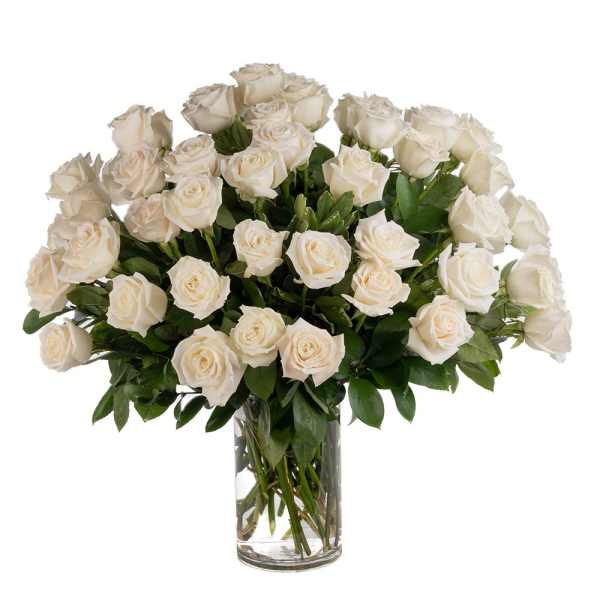 Large arrangement of white roses in a clear glass vase
