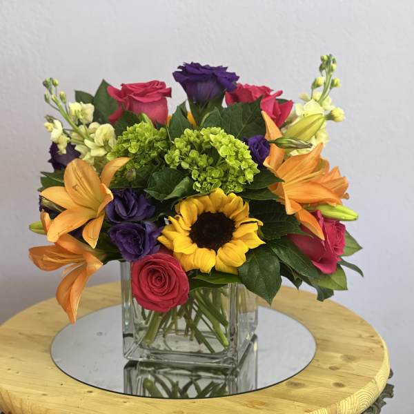 Colorful mixed bouquet in a square glass vase